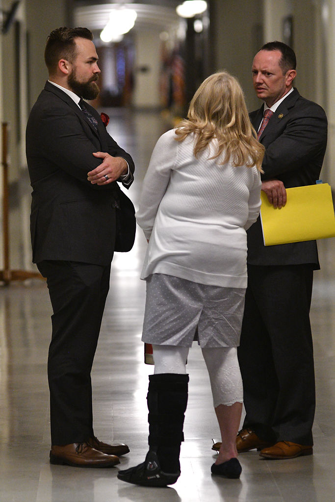 From left, Representative Nick Schroer, Sen. Jeanie Riddle and Sen. Eric Burlison talk in the hallway